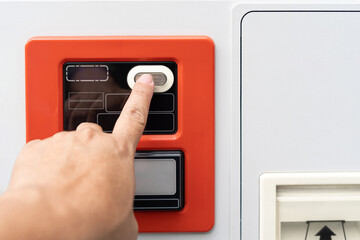Close up hand a man Press the button of water vending machines. select the desired product and...