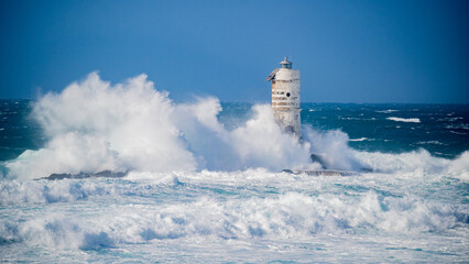 The lighthouse of the Mangiabarche shrouded by the waves of a mistral wind storm

