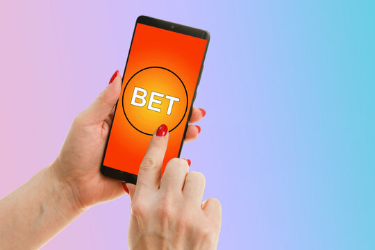 hands of a woman holding a online betting device. All screen graphics are made up.