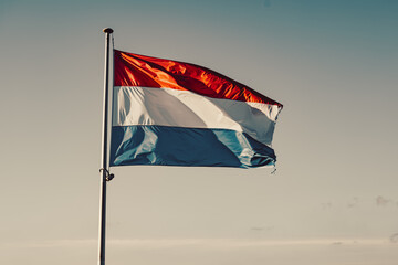 the flag of luxembourg at sunset. close up of luxembourg flag waving in the sky