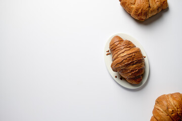 Croissants on a white background top view, space for text,Croissant with chocolate on a white background with copy space