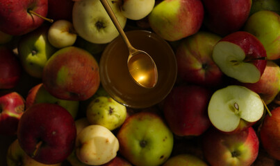 A spoon with transparent honey on a background of blur apples