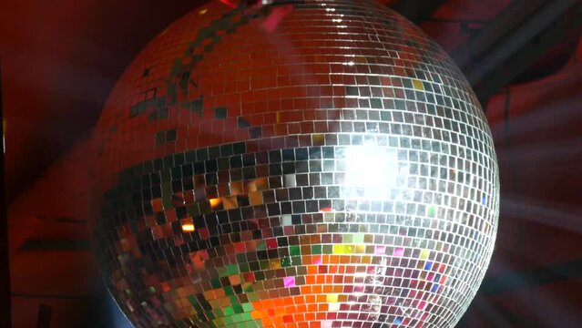 Silver mirror disco ball at a party or celebration. Lighting design on the stage of the birthday party in the club. Abstract background of retro disco ball