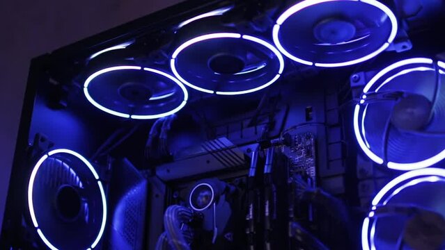 Modern gaming computer with flashing blue and white illumination in the dark
