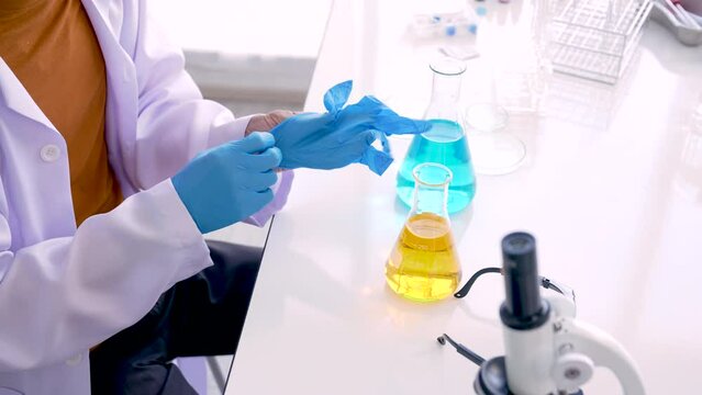 4K, Close Up Hands of a science teacher wearing blue gloves mixing lab chemicals in a prep school science room. Concept education, Science experiments, Chemistry and Children