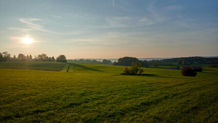 Golden hour at the small Bavarian village aufkirchen, behind the hills under the fog there is Starnberger See