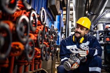 Industrial maintenance service and experienced engineer changing pipe valves in refinery plant.