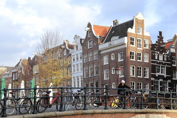 Amsterdam Singel Canal Bridge View with Historic Architecture and Walking Woman, Netherlands