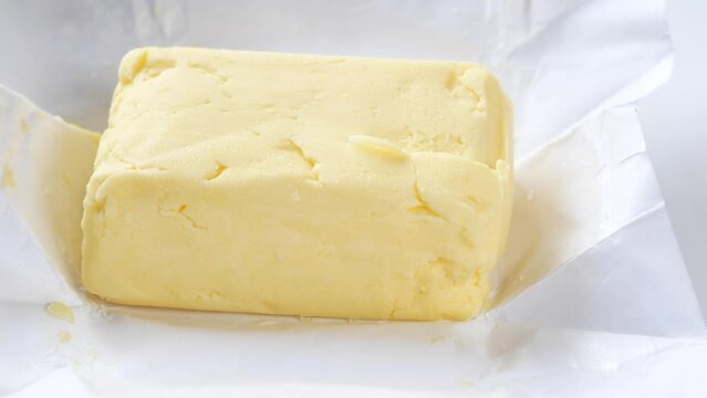 slice of a butter on a paper on table 