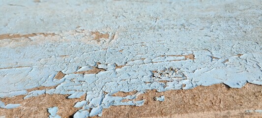 Old wooden painted surface. Abstract blue textured background. Old peeling paint on the table.
