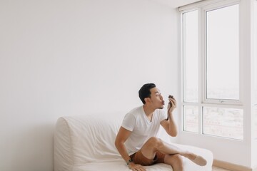 Single asian man playing with his sugarglider pet alone in his apartment. High quality photo