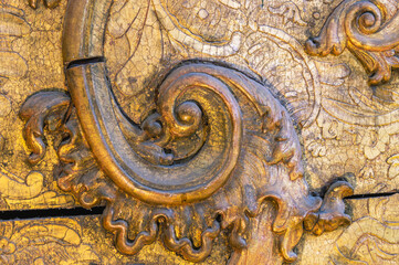 The background of a gilded wooden iconostasis made in the 16th century.An old carved iconostasis of the 16th century.Ancient carved patterns on the wooden surface. Religious images on a wooden surface