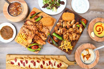 Delicious meat kebab with fresh vegetable salad served with variety of Turkish dishes and appetizers. Top view of assorted Turkish food and meze, tasty and healthy Mediterranean cuisine.