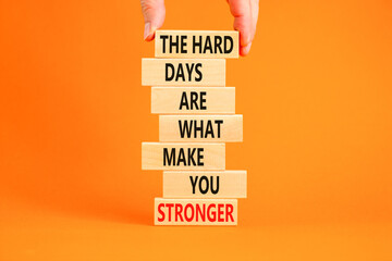 Support and be stronger symbol. Concept words The hard days are what make you stronger on wooden blocks. Bussinesman hand. Beautiful orange background. Business and be stronger concept. Copy space.