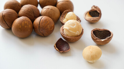 Macadamia nut. Whole and open nuts, shell fragments on a white background top view
