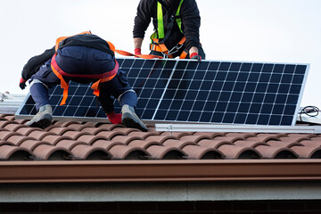 Dos técnicos instalando placas solares en una vivienda. - 533012247