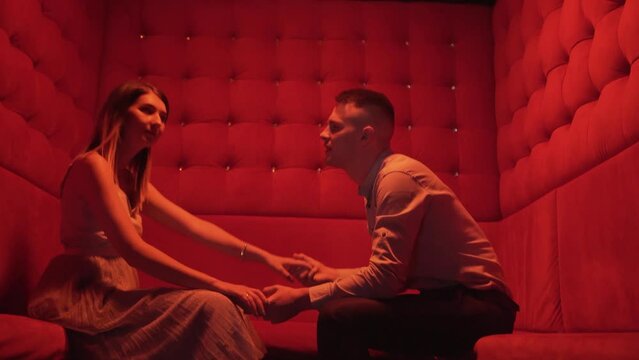 Playful drunk couple making out at party in night club, passionate kiss at disco