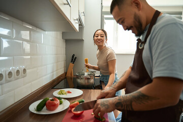 Husband and wife cooking food together in the kitchen