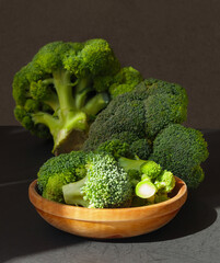 Fresh green broccoli in brown wooden bowl.