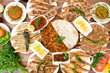 Delicious meat kebab with fresh vegetable salad served with variety of Turkish dishes and appetizers. Top view of assorted Turkish food and meze, tasty and healthy Mediterranean cuisine.