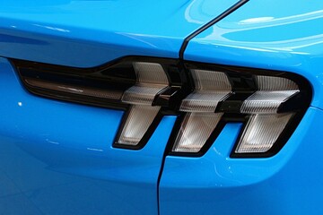 Detail of rear LED lights of modern electric american compact crossover car, light blue color, displayed on automobile expo.  - obrazy, fototapety, plakaty