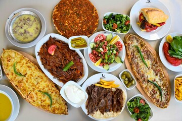 Delicious meat kebab with fresh vegetable salad served with variety of Turkish dishes and appetizers. Top view of assorted Turkish food and meze, tasty and healthy Mediterranean cuisine.