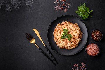 Tasty appetizing classic italian pasta with tomato sauce and cheese on plate on dark background