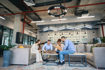Businesspeople holding business meeting at coffee table in co-working space - obrazy, fototapety, plakaty