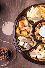 Cheese plate with honey, nuts on brown table, flat lay. Space for text