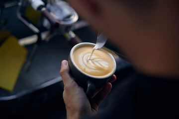 men's hands pouring milk and preparing fresh cappuccino, coffee pot and cooking concept, morning coffee
