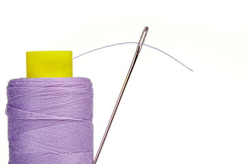 Macro skein of thread purple colors with a needle on a white background