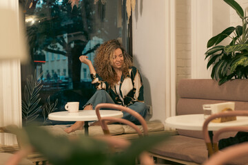 Pretty Young Woman With Curly Hair Relaxing In Cafe 