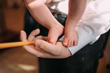 children's feet in a man's hand at a baptism