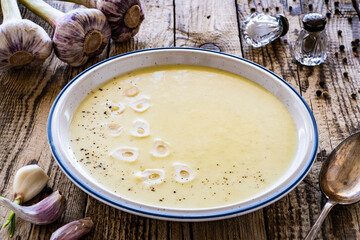 Cream garlic soup on wooden table
