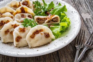 Dumplings - meat dumplings with onion and bacon on  wooden table
