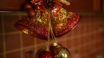 Selective focus on gilded wind chimes bells - Christmas decoration hanging on a wooden kitchen cabinet or cupboard