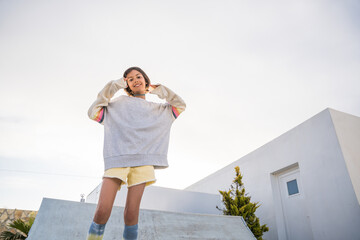 Overjoyed teen girl in street style clothes looking at the camera and smiling toothy