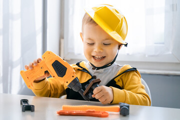 Child play with work tools at home, dreams to be an engineer. Little boy builder. Education, and...