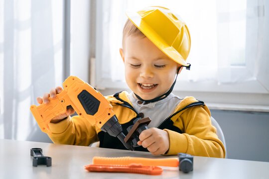Child play with work tools at home, dreams to be an engineer. Little boy builder. Education, and imagination, purposefulness concept. Kid and drill