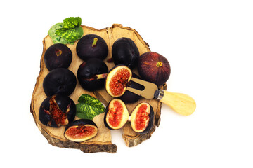 Dark figs on a wooden board on an orange background. Shallow depth of field