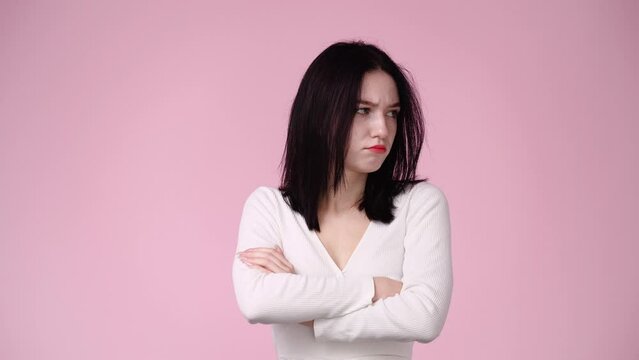 4k video of grumpy woman on pink background.