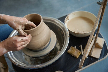 Potter hands in the process of working with clay product