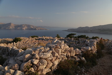 Sunset over the sea and stone walls on the island of Krk, Croatia.
