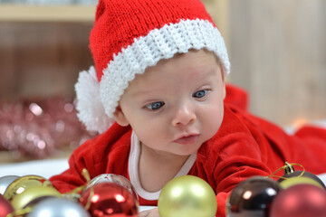 Obraz na płótnie Canvas Portrait of a newborn baby in Christmas clothes and Santa hat.