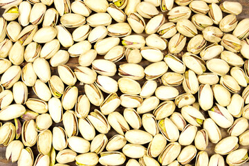 Pistachios texture and background . Tasty pistachios on wood table