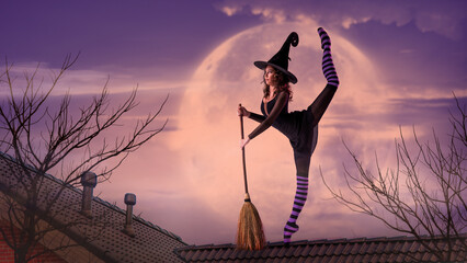 ballerina on pointe shoes in a black witch costume in a hat and with a broom dances on the roof...