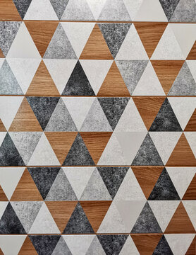 Ceramic tiled wall detail with textured triangles pattern of neutral palette