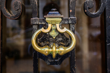 Antique forged handle on the door close-up on a sunny day.