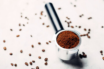 Portafilter with ground coffee on a white background. Coffee background