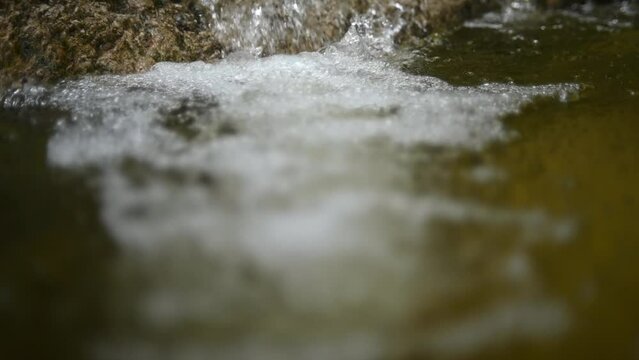 Bubbles on water in a pool  of a mountain river (slow motion, bokeh)